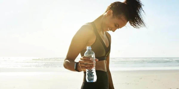 donna che mostra come idratarsi e fare sport fa bene al metabolismo