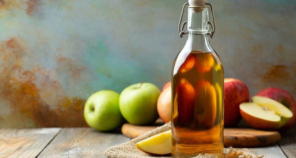 L'immagine mostra una bottiglia di aceto di mele, che bevuto a colazione ha molti benefici per il benessere del corpo.